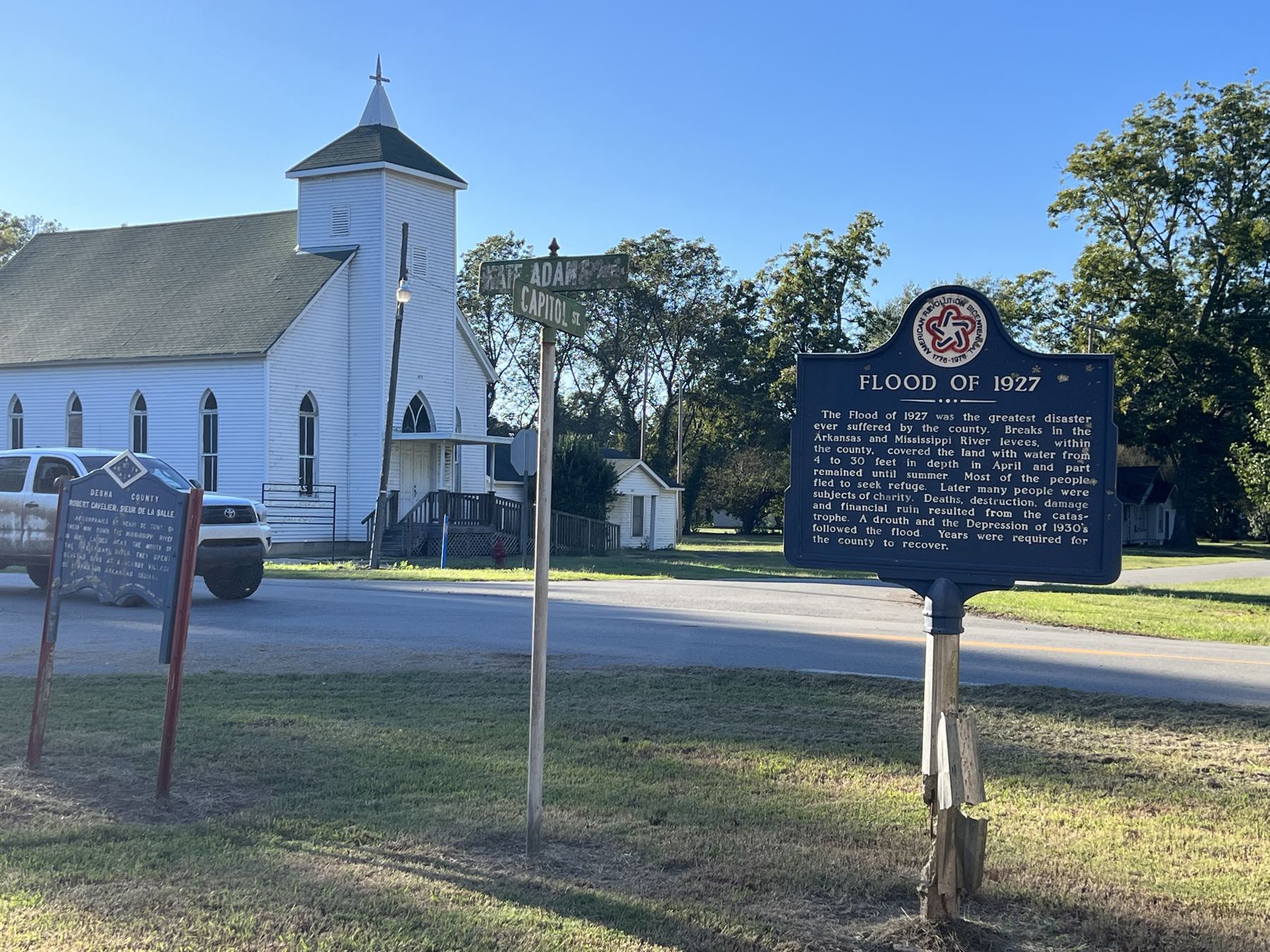 A clapboard church and the Flood of 1927 marker in Arkansas City