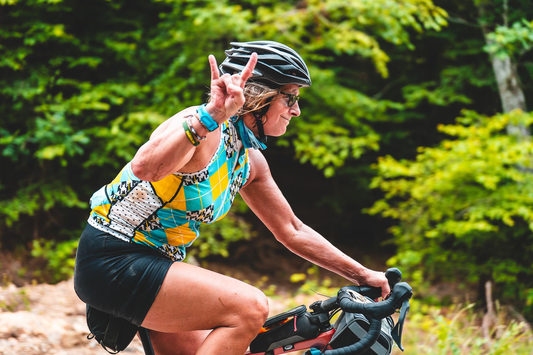 A rider on wooded gravel throwing a rock-on sign