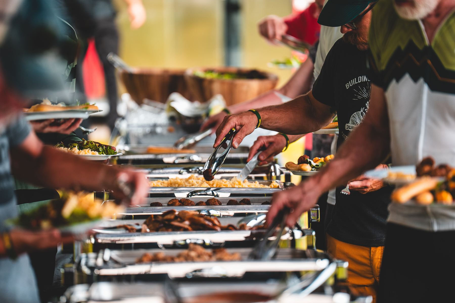 Riders filling plates along the serving line at camp