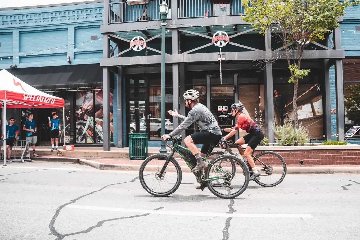 Two riders rolling past the Gearhead storefront on Main Street in Jonesboro