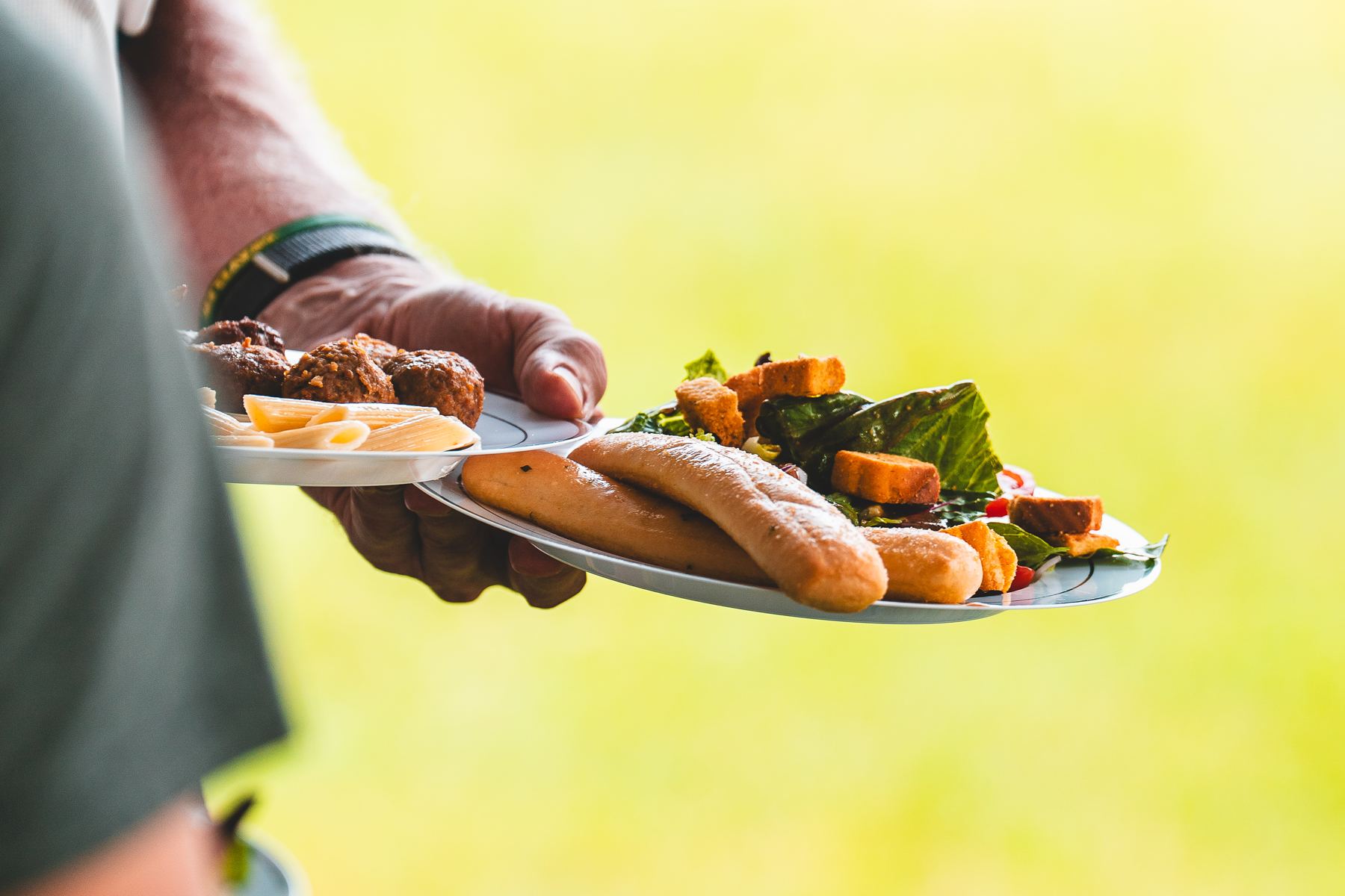 A rider carrying two loaded plates away from the dinner line